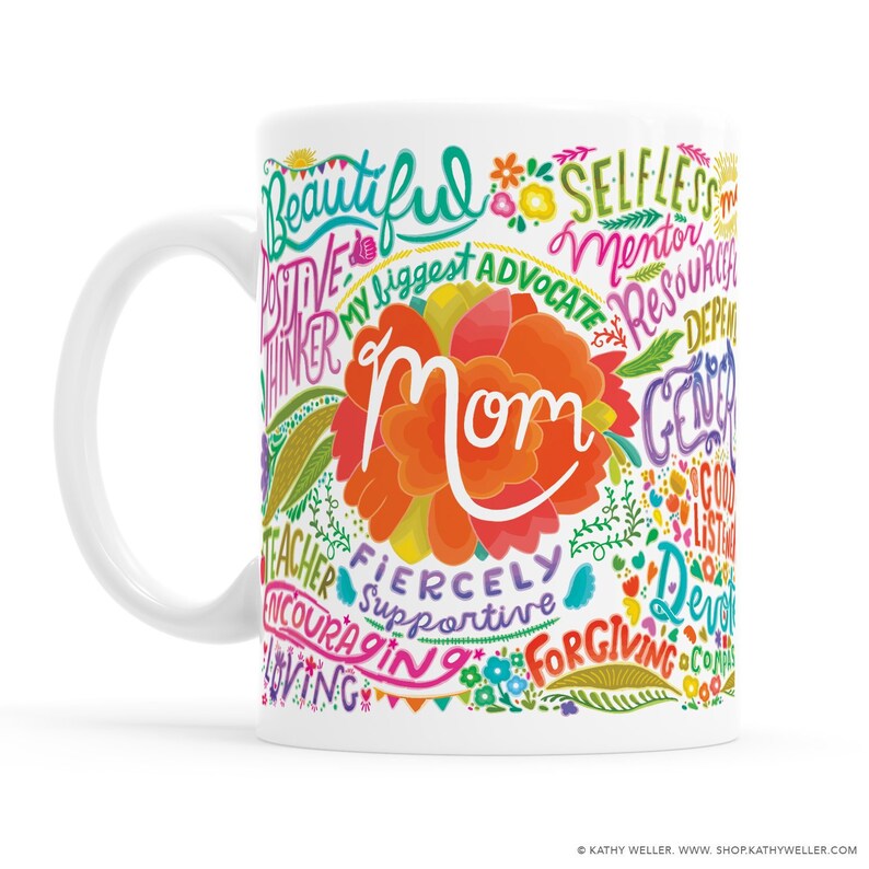 May include: White ceramic mug with a colorful design featuring the word "Mom" surrounded by words describing positive qualities, such as "beautiful", "supportive", "generous", and "forgiving".