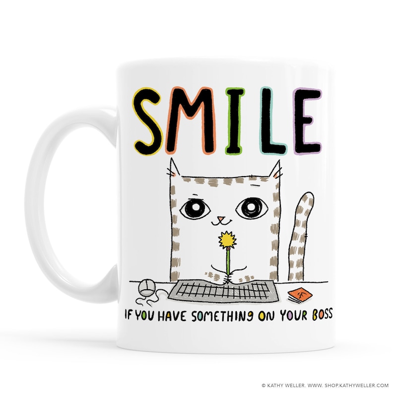 May include: White ceramic mug with a cartoon cat holding a flower and the text "SMILE IF YOU HAVE SOMETHING ON YOUR BOSS".