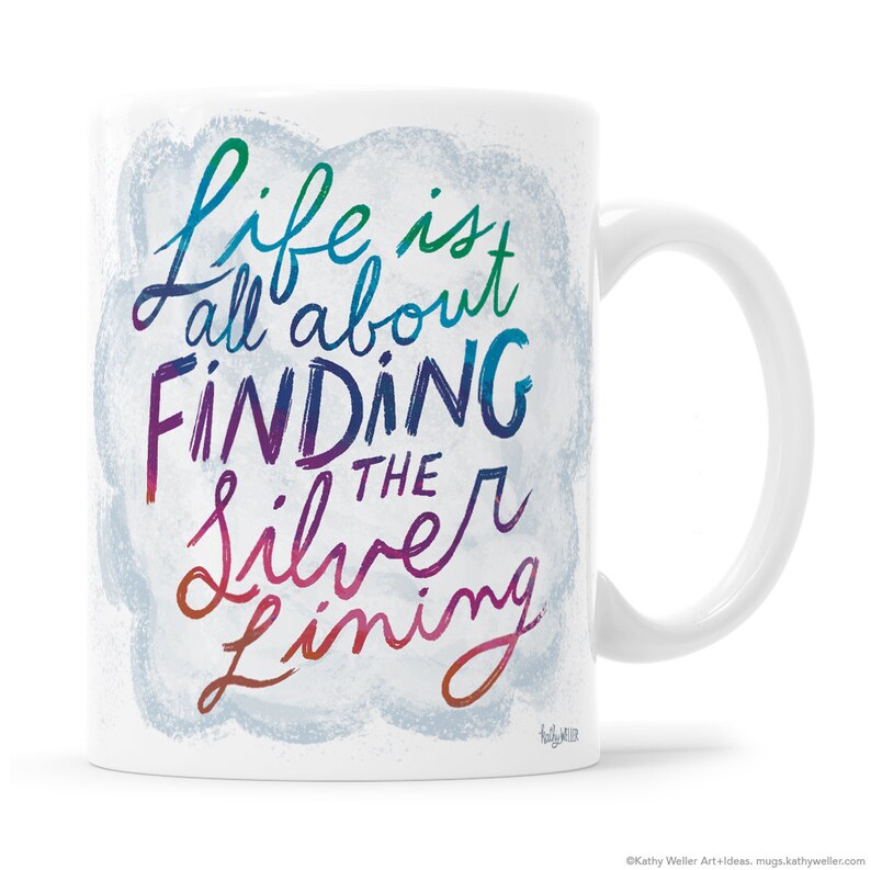 May include: White ceramic mug with a colorful design that says "Life is all about finding the silver lining".