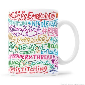 May include: White ceramic mug with a colorful design featuring the words "I love embroidery", "stitch", "needle art", "fancy work", "ribbon", "hand embroidery", "embroidery love", "custom", "needle", "embroidery thread", "thread", "painting", "cross stitching" and more.