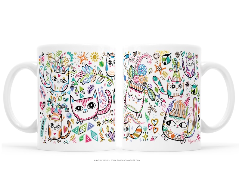 May include: White ceramic mug with a colorful design of cats with flowers, geometric shapes, and stars. The mug has a handle on the left side.