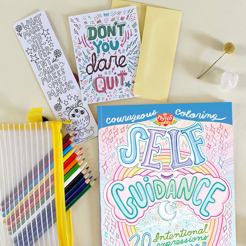 K&ouml;nnte beinhalten: Ein blaues Malbuch mit dem Titel "Courageous Self Guidance" und einem Regenbogen-Design. Das Buch enth&auml;lt 20 bewusste Ausdr&uuml;cke. Das Bild zeigt auch einen Satz Buntstifte, ein Lesezeichen mit dem Text "What makes me different also makes me magic" und eine Karte mit dem Text "Don't you dare quit".