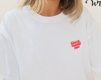 May include: White t-shirt with a red heart graphic that says "Lover of cancelled plans".
