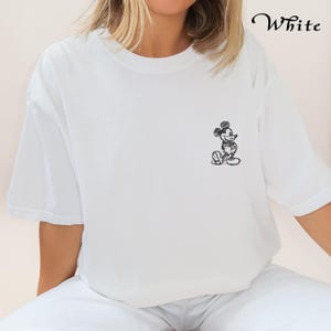 May include: White t-shirt featuring a black and white sketch of Mickey Mouse on the front.