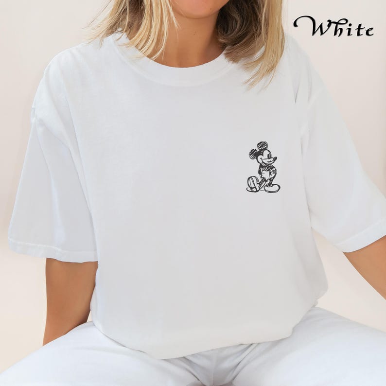 May include: White t-shirt featuring a black and white sketch of Mickey Mouse on the front.