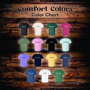Puede incluir: Una carta de colores que muestra una variedad de camisetas Comfort Colors. Las camisetas est&aacute;n dispuestas en filas y columnas, mostrando colores como pimienta, marfil, azul abeto, carmes&iacute;, musgo, flor, negro, chambray, violeta, azul marino, mantequilla, mezclilla, azul vaquero, blanco y verde claro.