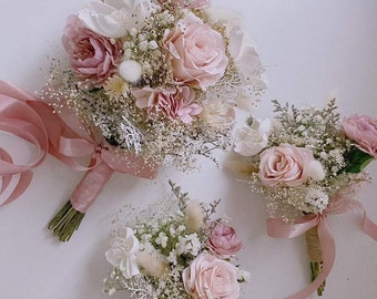 Chic and elegant wrist corsage for prom or special occasions featuring soft pink roses, greenery, and ribbon accents.