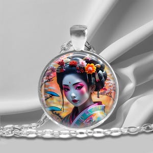以下が含まれることがあります： ピンクのメイクと花の髪飾りをした芸者のカラフルなイラストが描かれた丸いペンダントが付いたシルバーチェーンネックレスです。