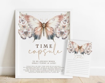 May include: A white framed print with a watercolor butterfly design and the text "TIME capsule TO BE OPENED WHEN EMALI TURNS 18 20XX!"  The print is accompanied by a smaller card with a similar butterfly design and the text "Dear Emali".