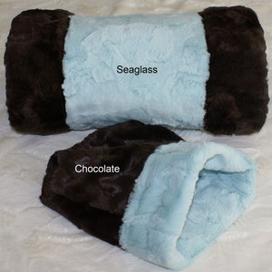 May include: Two plush fabric pet beds, one in a light blue color with a brown trim and the other in a brown color with a light blue trim. The light blue bed is labeled "Seaglass" and the brown bed is labeled "Chocolate".