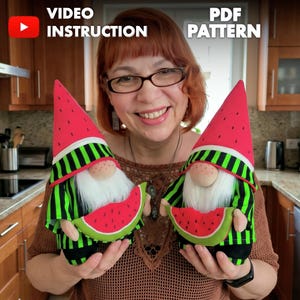 May include: Two handmade fabric gnomes featuring tall red watermelon-patterned hats with black seeds, green and black striped shirts, white faux fur beards, and small plush watermelon slices held in their hands. Text reads Video Instruction PDF Pattern.