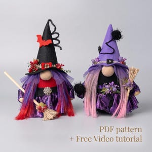 May include: Two decorative gnome figures dressed as witches. One wears a black hat with a red bat and red berries, the other a purple hat with a black pom-pom. Both have long hair, purple metallic skirts, and hold small straw brooms. Text: PDF pattern + Free Video tutorial.
