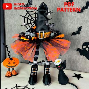May include: A Halloween witch doll with a black hat, orange and black tutu, and striped legs. The doll has black boots and is decorated with a spider, bat, and web. The words "VIDEO INSTRUCTION" and "PDF PATTERN" are visible.