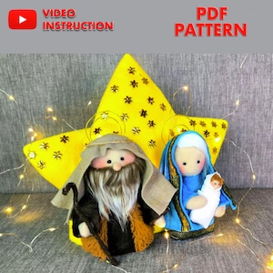 May include: Handmade felt nativity scene with a yellow star, Joseph, Mary, and baby Jesus. Joseph has a long white beard and holds a staff. Mary wears a blue robe and holds baby Jesus. The star has black flower accents. Text: VIDEO INSTRUCTION, PDF PATTERN.