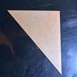 K&ouml;nnte beinhalten: Ein klares, dreieckiges Acrylteil mit den Worten "small" und "exit" auf der Oberfl&auml;che. Das Teil hat eine hellbraune Farbe und liegt auf einer dunklen, reflektierenden Oberfl&auml;che.