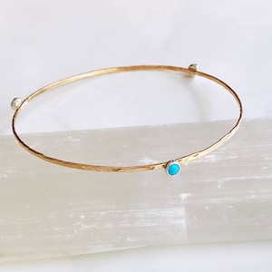 Peut inclure: Un bracelet jonc en or avec trois pierres turquoise serties d'argent.