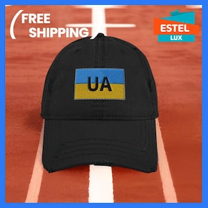 May include: Black distressed baseball cap with a yellow and blue embroidered patch featuring the letters "UA" in black.