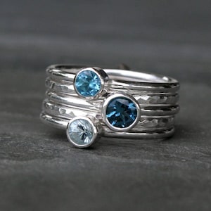 Blue topaz stacking rings. Five sterling silver stacking ring set includes one 5mm faceted london blue topaz ring, one 4mm swiss blue topaz ring and one sky blue topaz ring. Also, two plain hammered ring bands that fit flush between the faceted rings