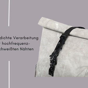 K&ouml;nnte beinhalten: Ein grauer, wasserdichter Rucksack mit einem schwarzen Gurt. Der Rucksack hat einen Rollverschluss und ist mit hochfrequenzgeschwei&szlig;ten N&auml;hten gefertigt.