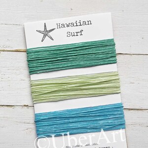 May include: Three spools of twine in shades of turquoise, mint green, and seafoam green. The spools are labeled "Hawaiian Surf" and "UberArt".