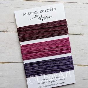 May include: Three spools of twine in maroon, magenta, and plum colors. Each spool contains five yards of twine. The label reads "Autumn Berries" and "UberArt" with the website address "www.Etsy.com/shop/UberArt".