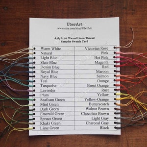 May include: A color chart of 4-ply Irish waxed linen thread sampler swatch card. The card shows a variety of colors, including warm white, natural, light blue, slate blue, denim blue, royal blue, navy blue, teal, turquoise, lavender, plum, seafoam green, mint green, dark green, emerald green, spruce green, khaki green, lime green, Victorian rose, pink, hot pink, magenta, red, maroon, salmon, orange, burnt orange, rust, yellow, yellow-orange, butterscotch, walnut brown, chocolate brown, light gray, charcoal gray, and black.