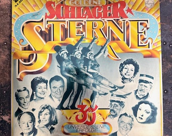 Può includere: Una copertina quadrata per disco in vinile intitolata Goldene Schlager Sterne. La copertina presenta un grande titolo dorato, un'illustrazione centrale di tre ballerini e ritratti di vari artisti. Il testo include 2 LP ALBUM e 30 UNVERGESSENE ERFOLGE.