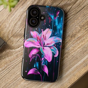 May include: A black phone case featuring a pink and blue flower design. The case has a camera lens cutout and a textured finish.