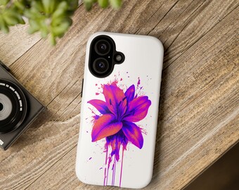 May include: A white phone case with a pink and purple flower design. The flower has a paint splatter effect and drips of paint.