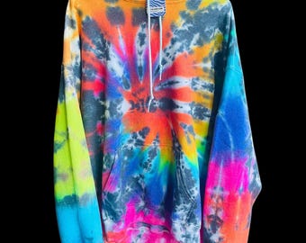 May include: A tie-dye hoodie with a bright rainbow color scheme. The hoodie has a black drawstring and a small tag that says "The Tie Dye Lab".