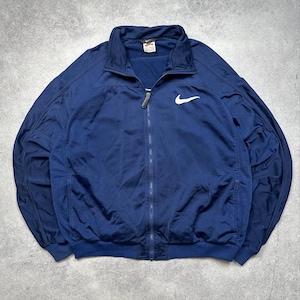 Pode incluir: Casaco de treino azul marinho com fecho de correr e log&oacute;tipo Nike branco no peito. Gola alta, punhos e bainha canelados. Uma pequena etiqueta Nike &eacute; vis&iacute;vel na gola.