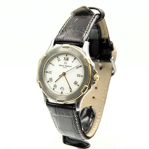 May include: A silver and gold-toned wristwatch with a white face and Roman numeral hour markers. The watch has a date display and is set on a dark brown leather band with a crocodile pattern.