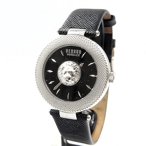 Puede incluir: Un reloj de pulsera Versus Versace con esfera negra, un emblema de cabeza de le&oacute;n plateado en el centro, marcadores de hora plateados y un bisel plateado texturizado. El reloj cuenta con una correa de cuero negro texturizado y hebilla.