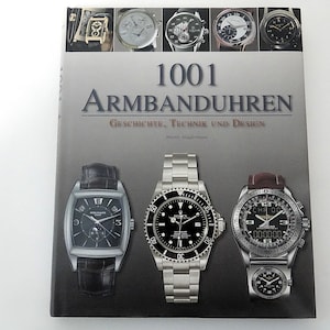 May include: A hardcover book titled 1001 Armbanduhren: Geschichte, Technik und Design. The cover features a grey gradient background with a collage of various wristwatches at the top and three prominent watches displayed in the center.