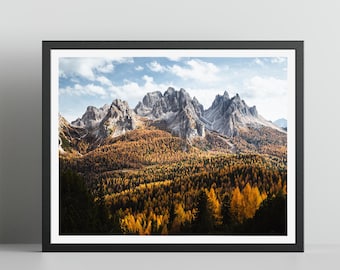 May include: A panoramic view of a mountain range with snow-capped peaks, surrounded by a forest of golden autumn leaves.
