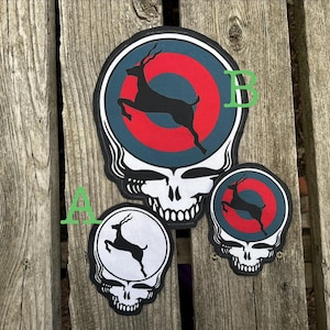 May include: Three embroidered patches featuring a stylized skull design with a leaping antelope silhouette. One large patch and one small patch display a red and blue circular target background, while one small patch features a white background.