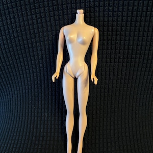 Könnte beinhalten: Ein Vintage-Puppenkörper in Nude-Farbe, ohne Kopf. Die Puppe hat bewegliche Arme und Beine, mit einer schlanken Taille und einem klassischen Retro-Design. Die Puppe besteht aus hartem Kunststoff.