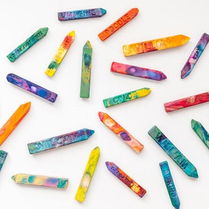 Puede incluir: Una colecci&oacute;n de l&aacute;pices de colores con varias palabras y frases impresas en ellos, incluyendo "Imagine", "Doodle", "You're Just Write", "You're So Sharp", "William", "Color", "Drawn To You", "Behind", y "Remarkable".