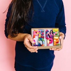 Image is a rainbow crayon name in letters that spell PENELOPE.  This custom crayon set is a perfect gift for a 2 year old. This personalized kids gift comes in a ready to gift box with name personalize on the outside.