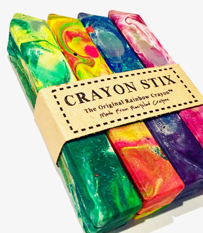 May include: A set of four Crayon Stix, the original rainbow crayons made from recycled crayons. The crayons are stacked and feature a variety of colors, including green, blue, red, and purple.