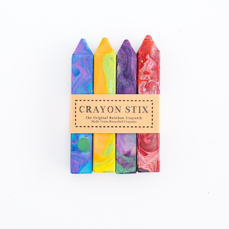 May include: Four colorful crayon stix, made from recycled crayons. The crayon stix are arranged in a row, with the label "Crayon Stix: The Original Rainbow Crayon&reg; Made From Recycled Crayons" visible in the center.