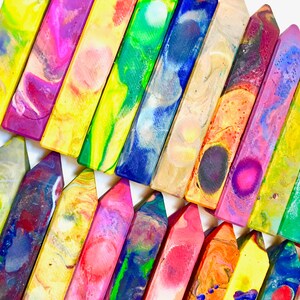 May include: A collection of colorful, swirled crayons arranged in a staggered pattern. The crayons are all different colors and have a unique, marbled appearance.