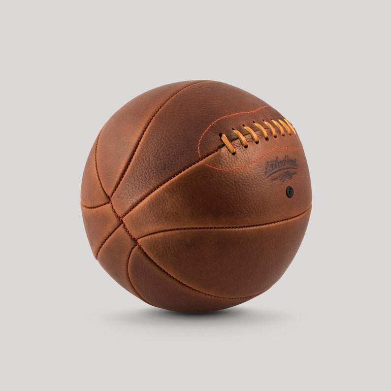 May include: A brown leather basketball with orange stitching and the text "Smith Street" in black.