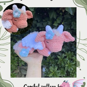 Op de afbeelding: Gehaakte draak in roze, wit en blauw, met een slaperige uitdrukking. De afbeelding bevat de tekst "Maisie the Sleepy Dragon" en "Crochet pattern by @joolscrochetplushies", wat duidt op een haakpatroon.