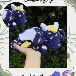 Könnte beinhalten: Ein handgehäkelter Drache in Marineblau mit gelben Sternen. Der Drache hat weiße und gelbe Details, mit dem Text "Maisie the Sleepy Dragon Celestial MOD" und "Crochet pattern by @joolscrochetplushies".