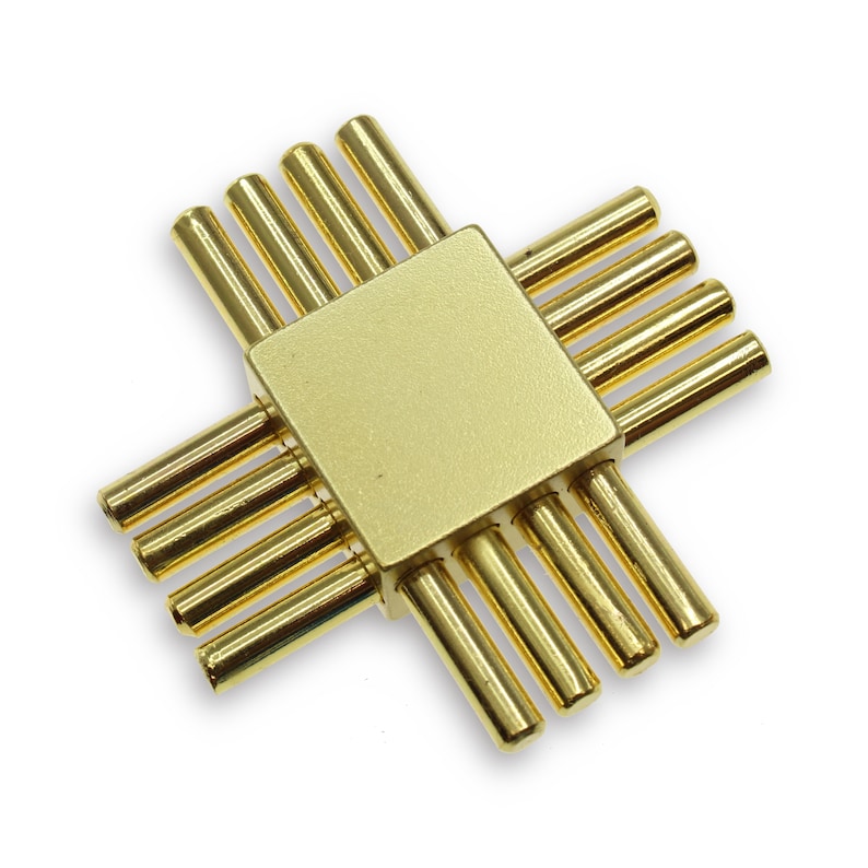 May include: Gold metal puzzle with a square center and eight arms extending out from each side. The arms are all the same length and are arranged in a symmetrical pattern.