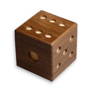 May include: A wooden cube with a hole in one side and six holes on the top. The cube is made of dark brown wood and has a natural wood finish.