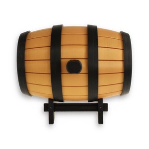 May include: A small wooden barrel with black metal hoops and a black metal stand. The barrel is made of light brown wood and has a slightly textured surface.