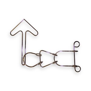 May include: A silver metal puzzle with a series of interlocking loops and a single arrow-shaped piece.