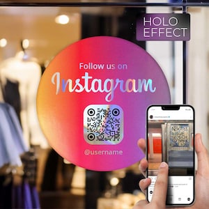 Op de afbeelding: Een holografische sticker met een roze, oranje en gele gradiënt, met de tekst "Follow us on Instagram" en een QR-code. Een telefoon toont een Instagram-bericht. De sticker heeft ook de tekst "Holo Effect" en "@username".